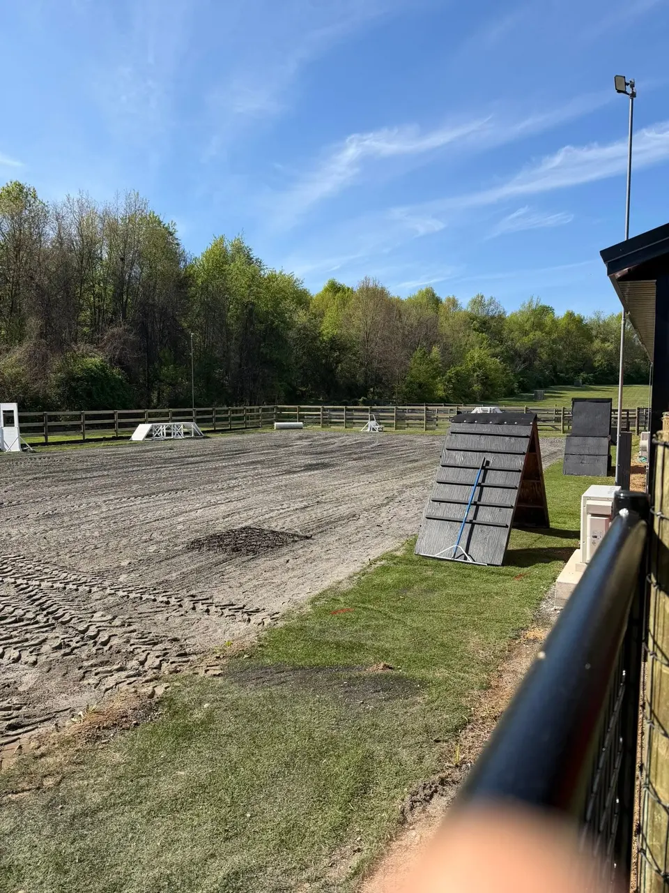 Outdoor training yard at Iron Rose K9 with agility equipment and fenced areas