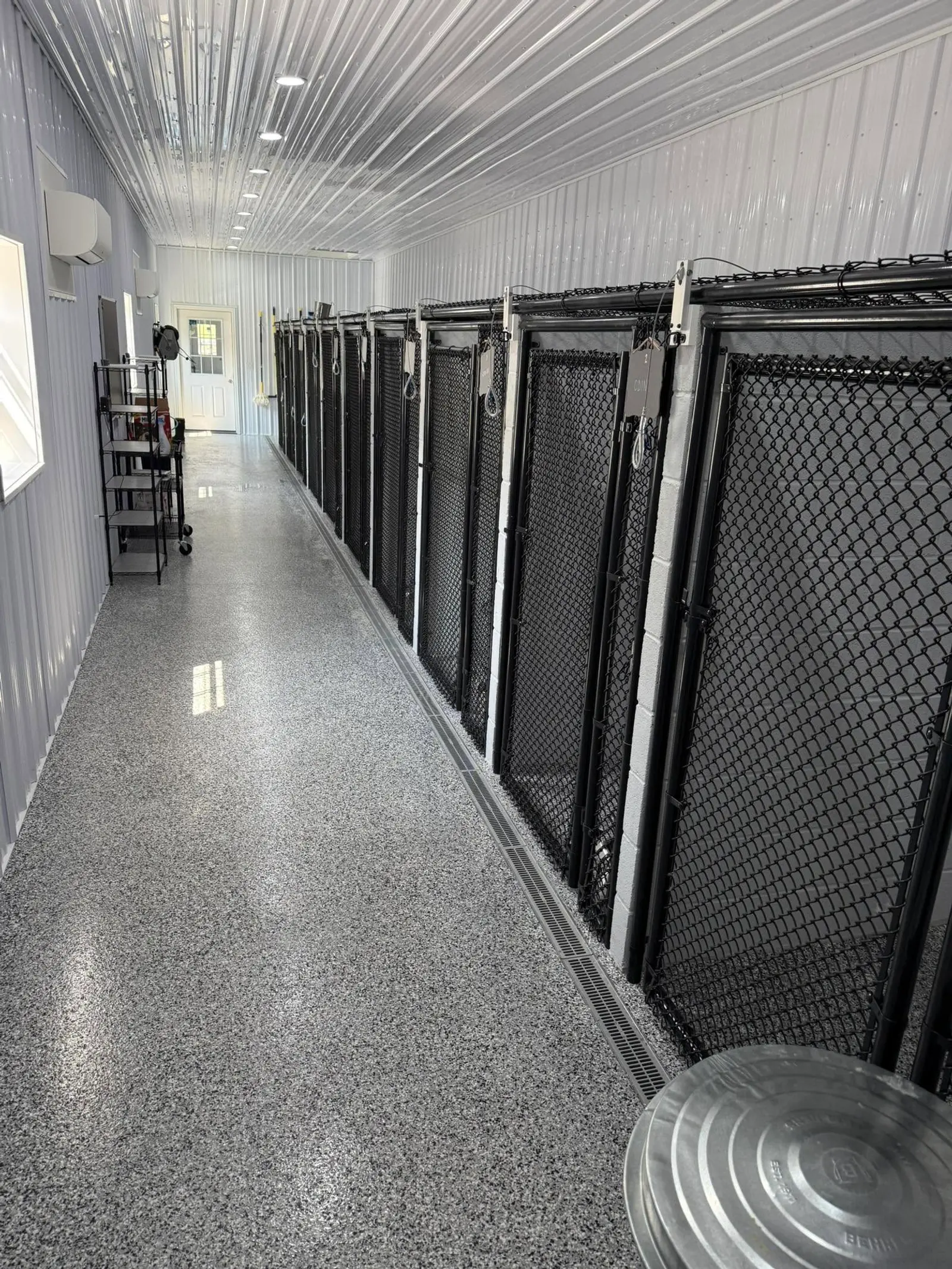 Clean indoor boarding aisle with individual kennel runs at Iron Rose Kennels