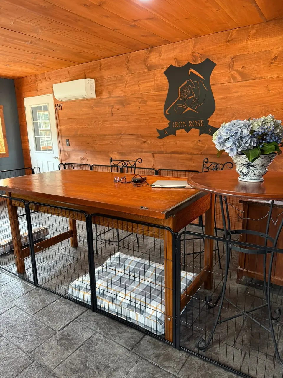 Reception room at Iron Rose K9 with the company logo on a wood-paneled wall